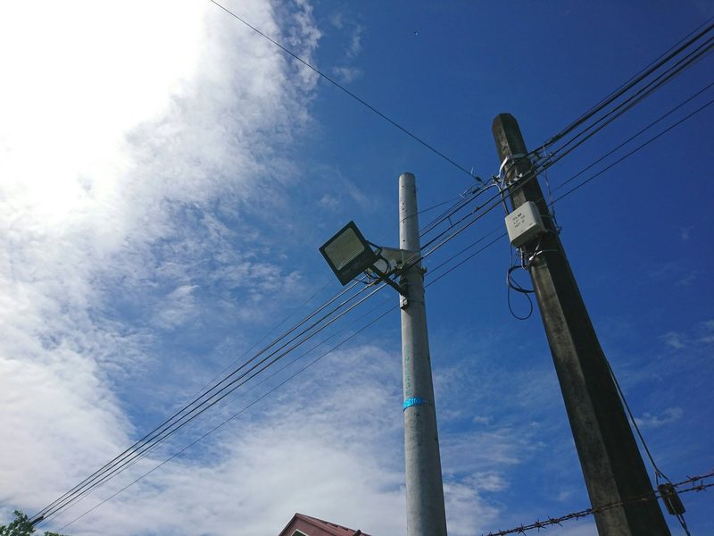Overhead power distribution lines against a blue sky