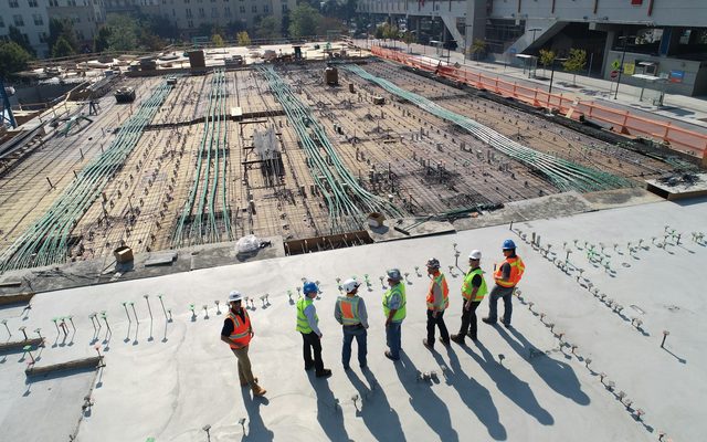 An engineering crew assembled across a live construction site