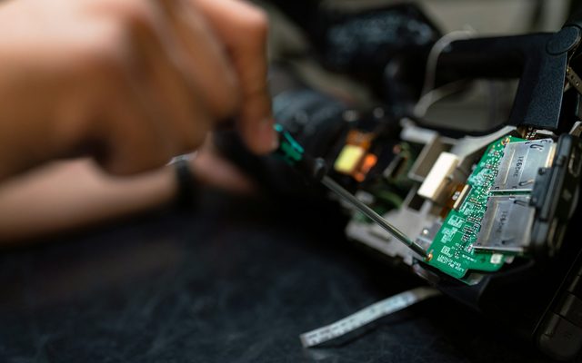 Hands assembling electronics on a workbench